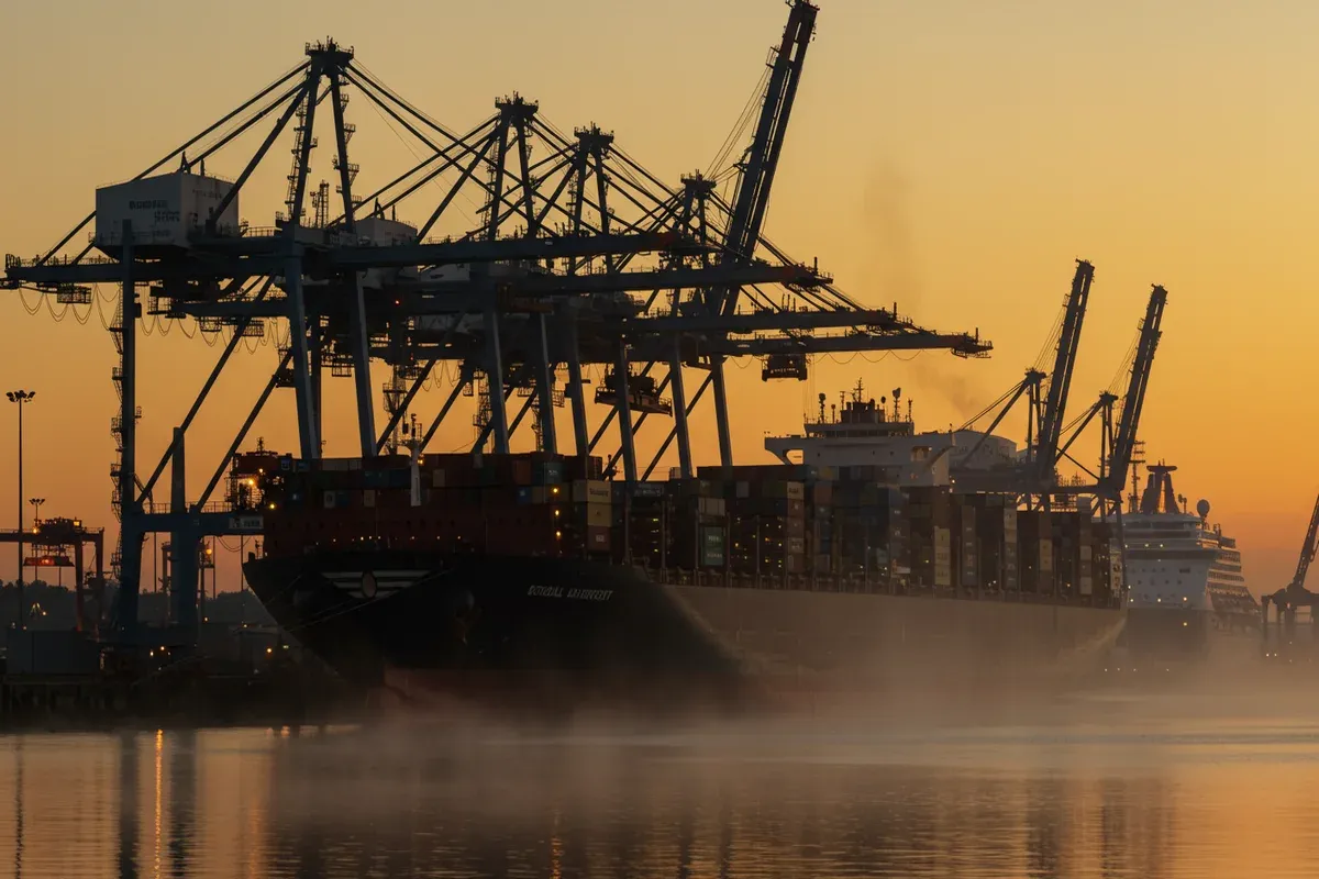 Tall cranes dominate the Northwest Tennessee Regional Port Authority waterfront reflecting in the misty gray water