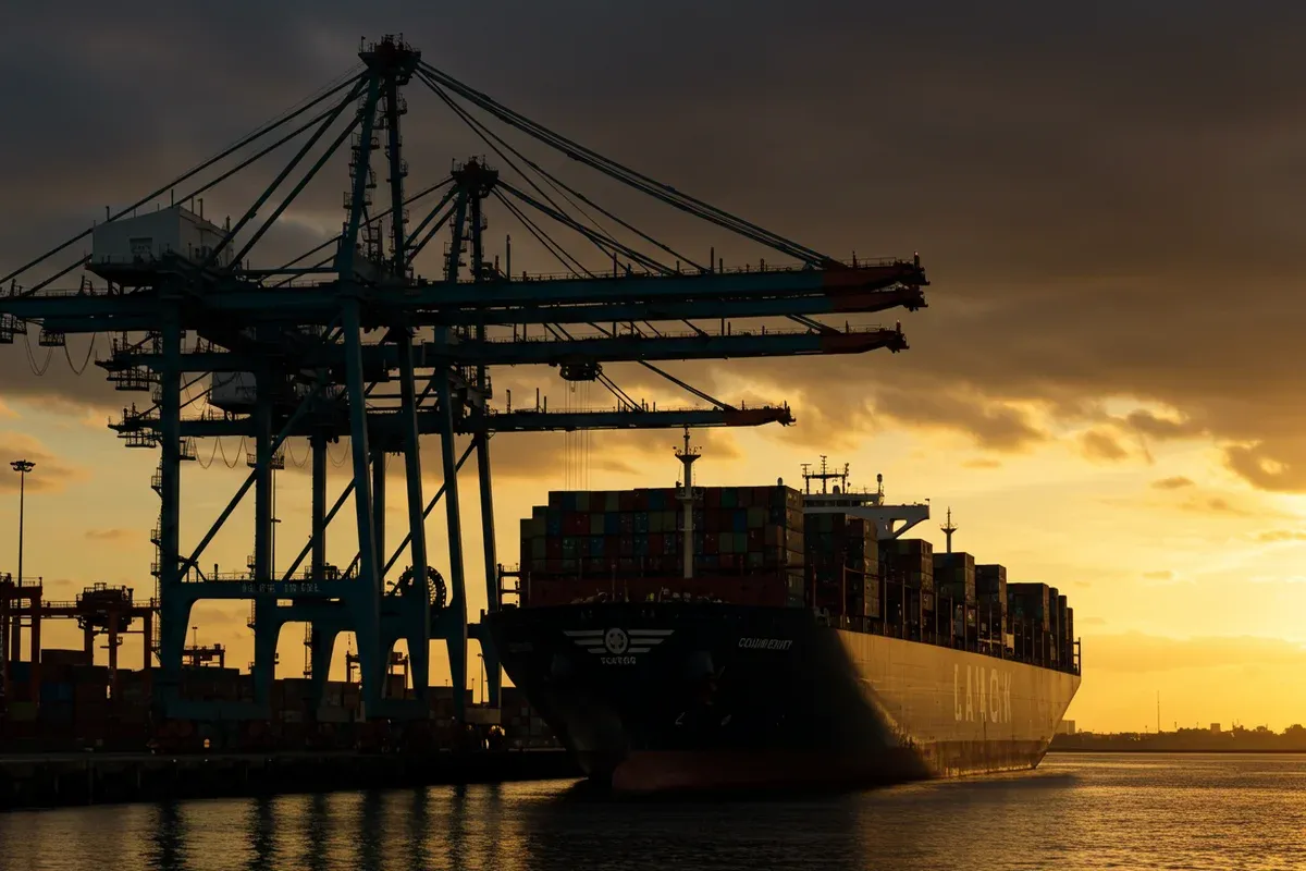 Tall cranes dominate the scene at the Port of Columbia County silhouetted against a dusky sky Cargo ships and industrial