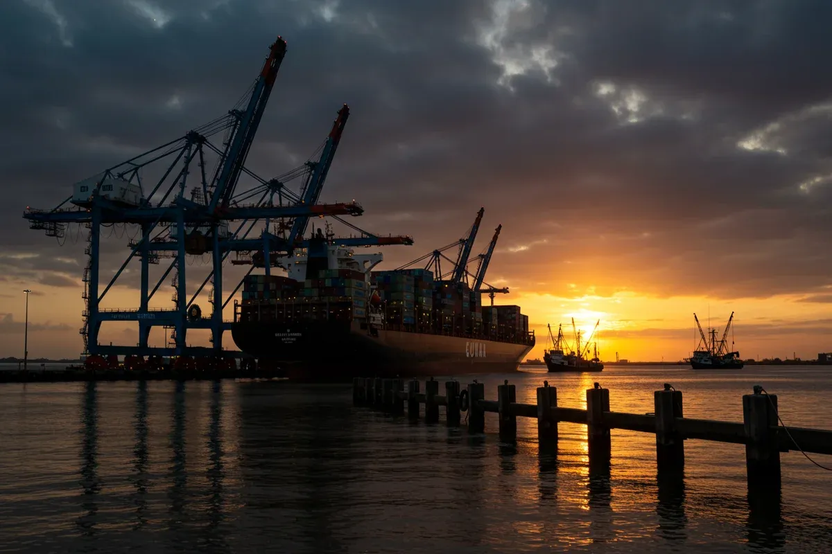 Cargo ships sail on the South Louisiana port waters reflecting a warm sunset light on the water and docks
