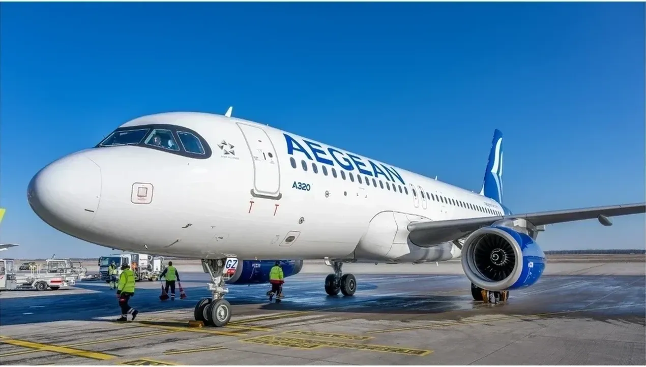 An Aegean Airlines Airbus A320 aircraft is being serviced on the tarmac with ground crew members assisting near the engines