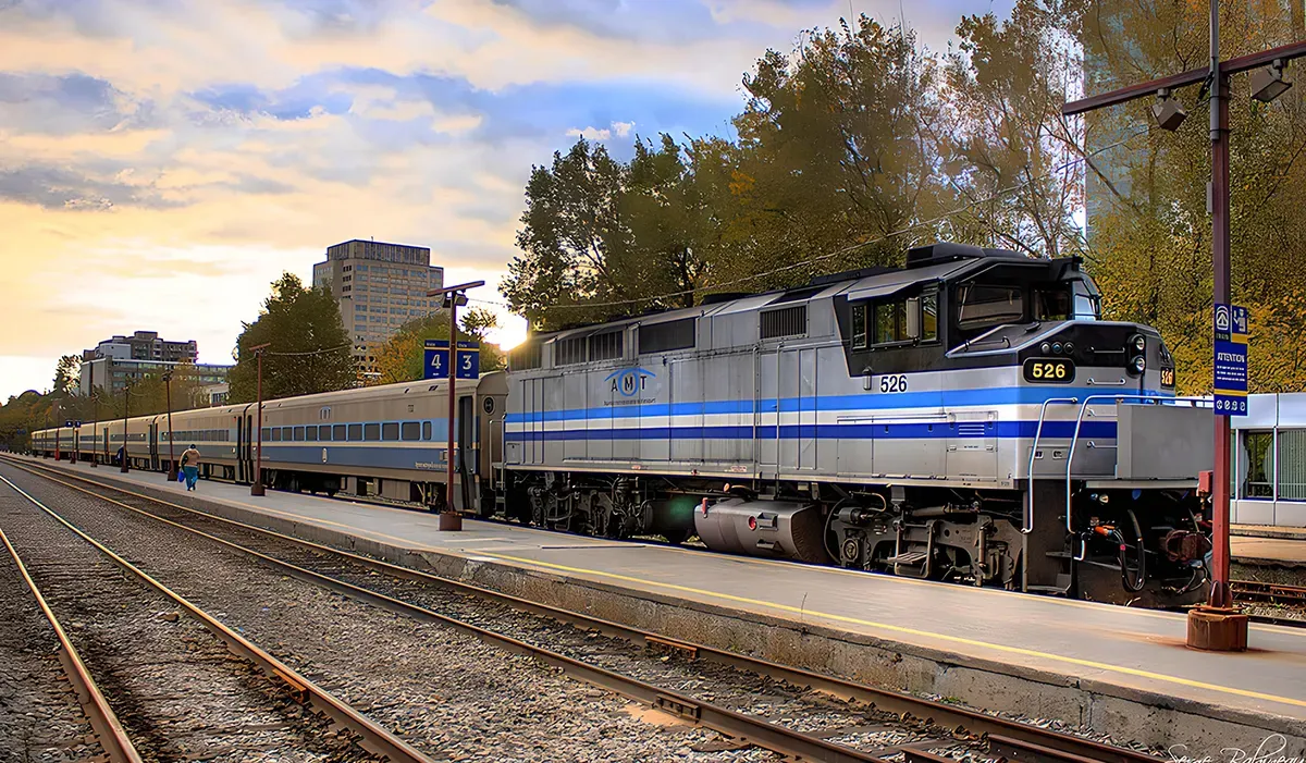 A blue AMT metro train sits on a platform with a sign indicating the trains route The train appears modern and efficient