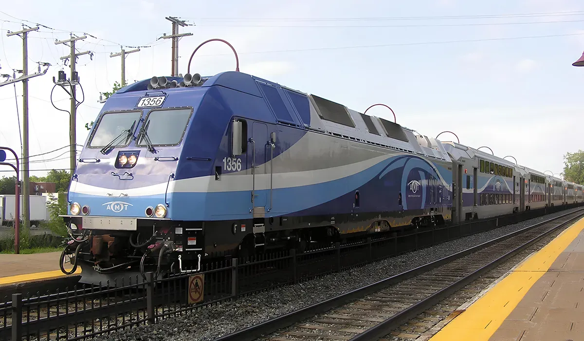 A blue Amtrak train sits on a platform with a yellow track beside it Its design features a streamlined shape and large