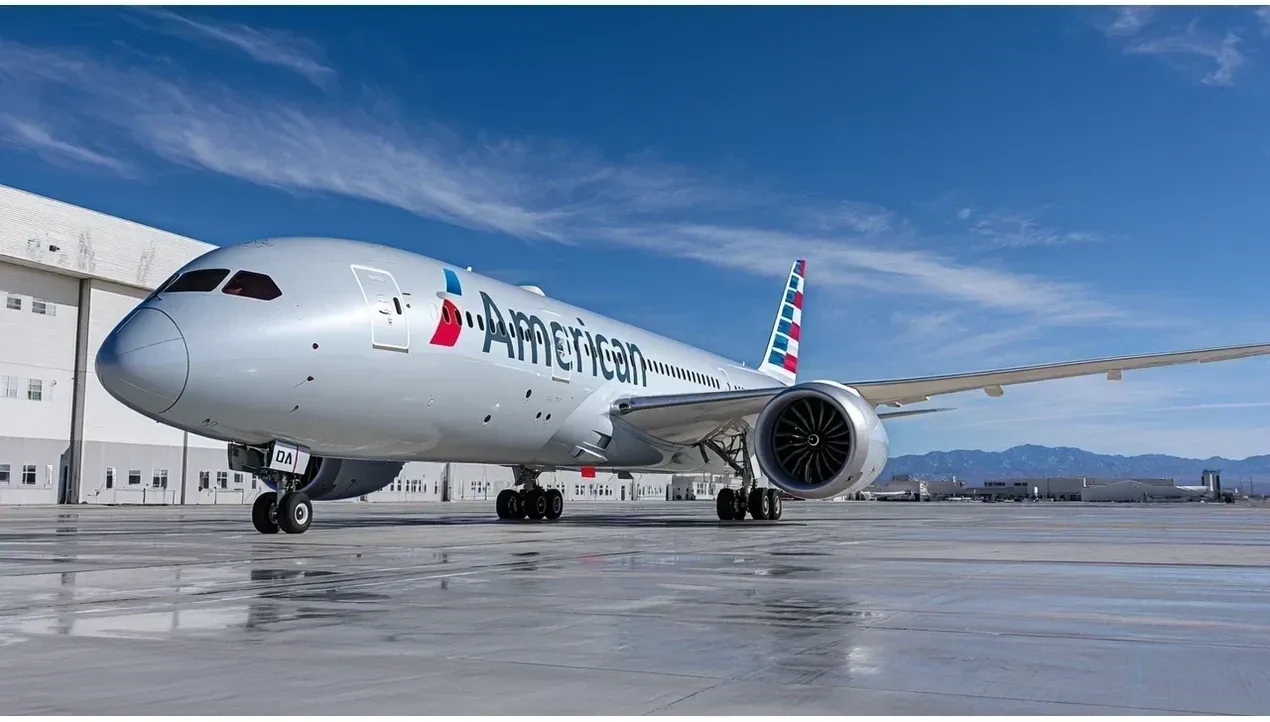 An American Airlines aircraft sits on the tarmac at an airport with mountains visible in the background ready for takeoff