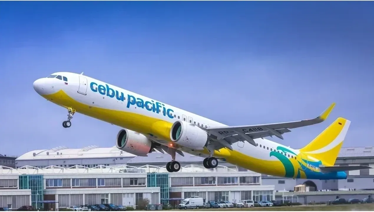 A Cebu Pacific airplane takes off against a modern airport backdrop vibrant yellow wings soaring into the sky