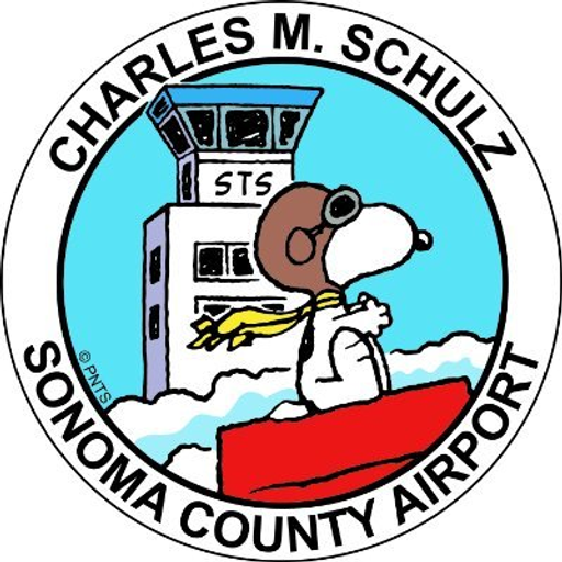 A smiling cartoon character resembling Charles Schulz stands proudly at Sonoma County Airport with a red scarf