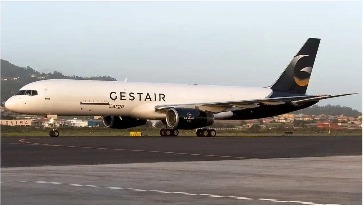 A white GESTAIR cargo aircraft stands on the tarmac with visible wheels and markings The plane appears ready for takeoff or