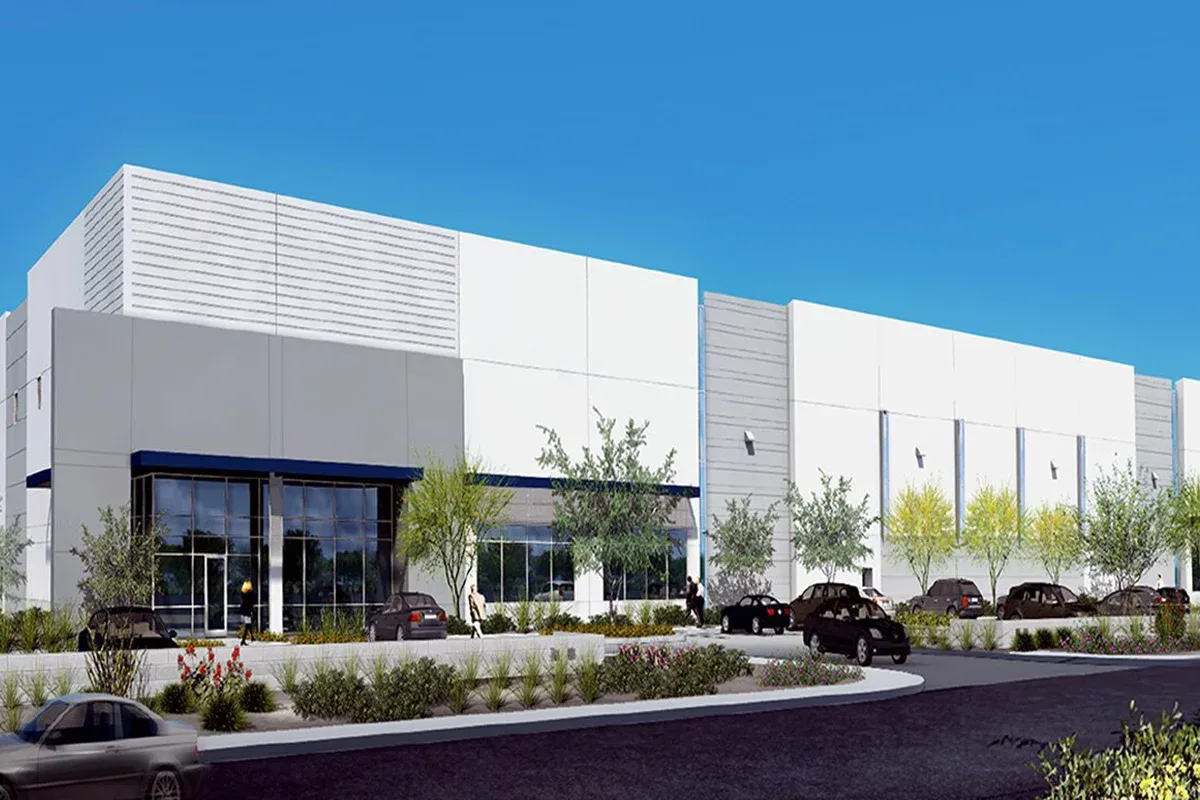 A modern warehouse building dominates the scene with expansive white walls and large blue tinted windows offering a glimpse
