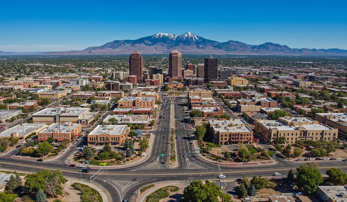 A wide aerial view showcases Albuquerque New Mexicos central avenue surrounded by tall buildings and lightcolored buildings