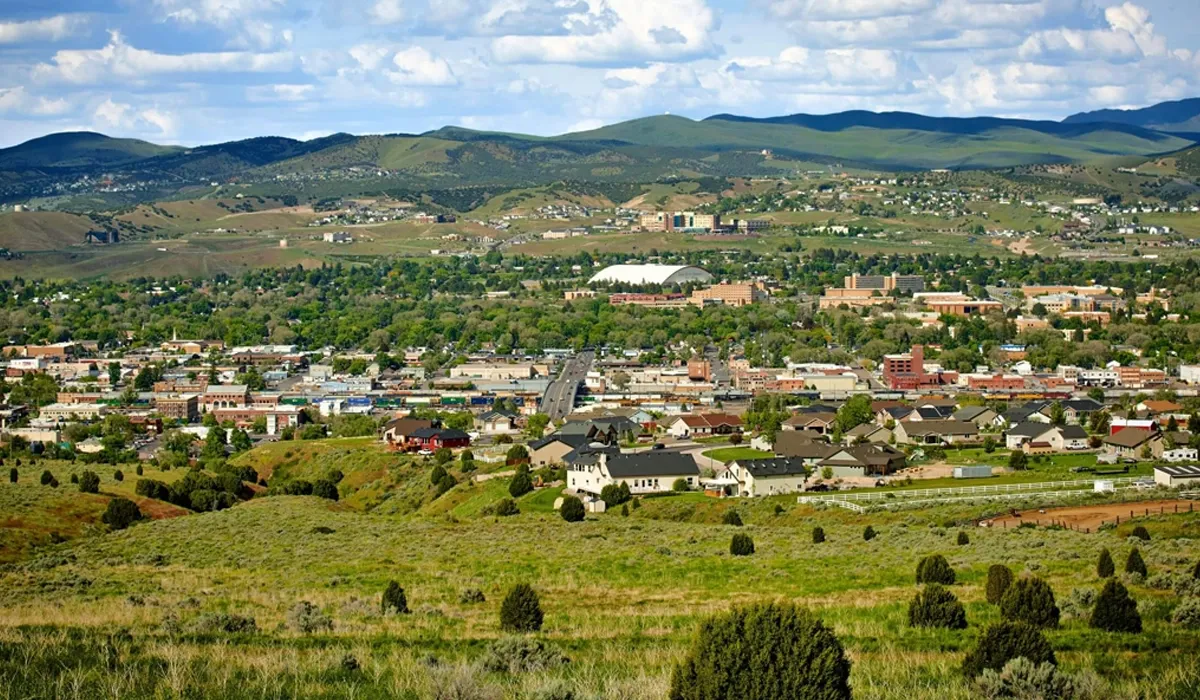A cityscape of Pocatello Idaho reveals buildings and a large stadium under a clear sky The scene showcases the citys